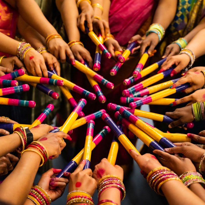 people with dandiya sticks celebrating navratri festival