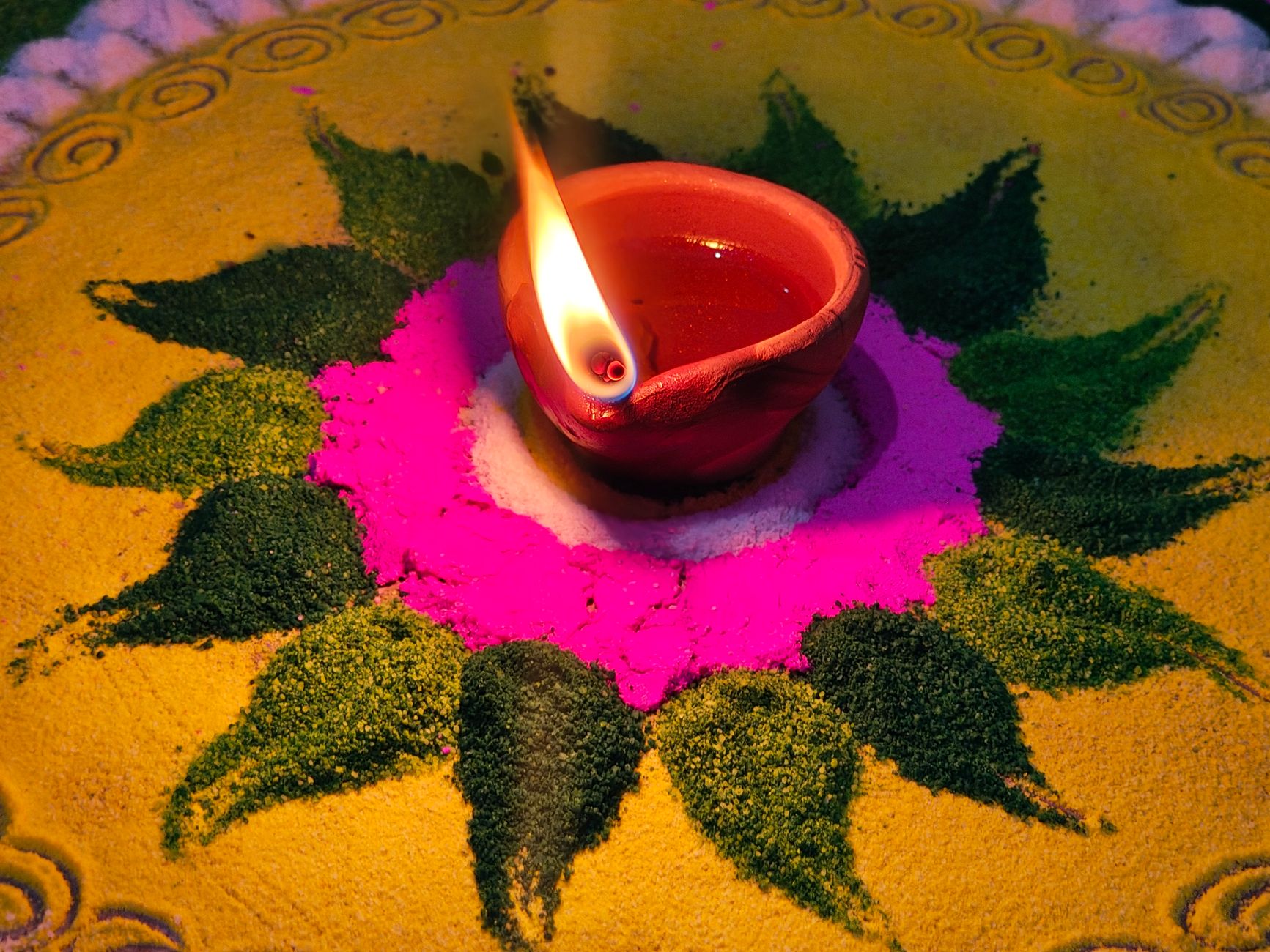 vibrant diwali rangoli with lit clay lamp