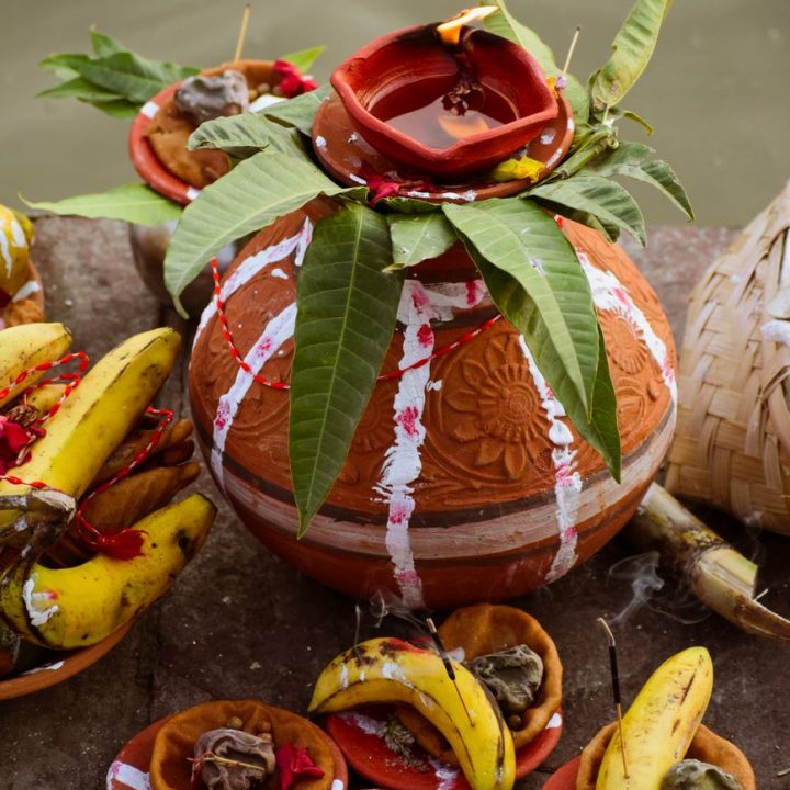 traditional indian clay pot with bananas and offerings