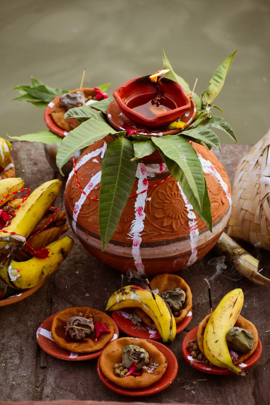 traditional indian clay pot with bananas and offerings