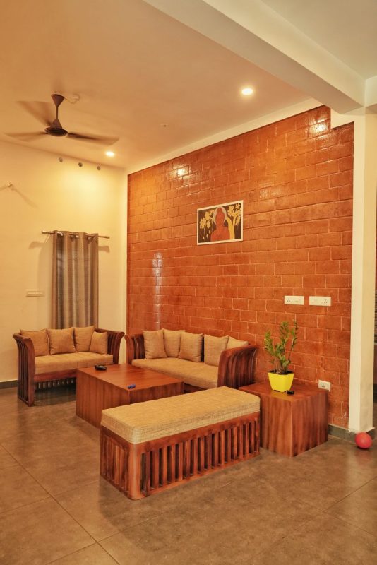 cozy living room with brick accent wall in kerala