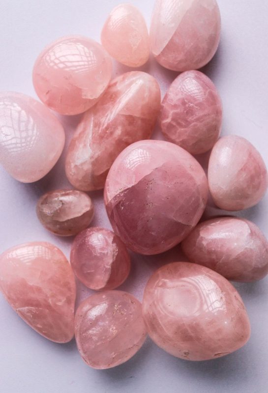close up of rose quartz gemstones on white surface
