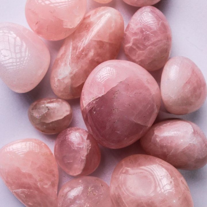 close up of rose quartz gemstones on white surface
