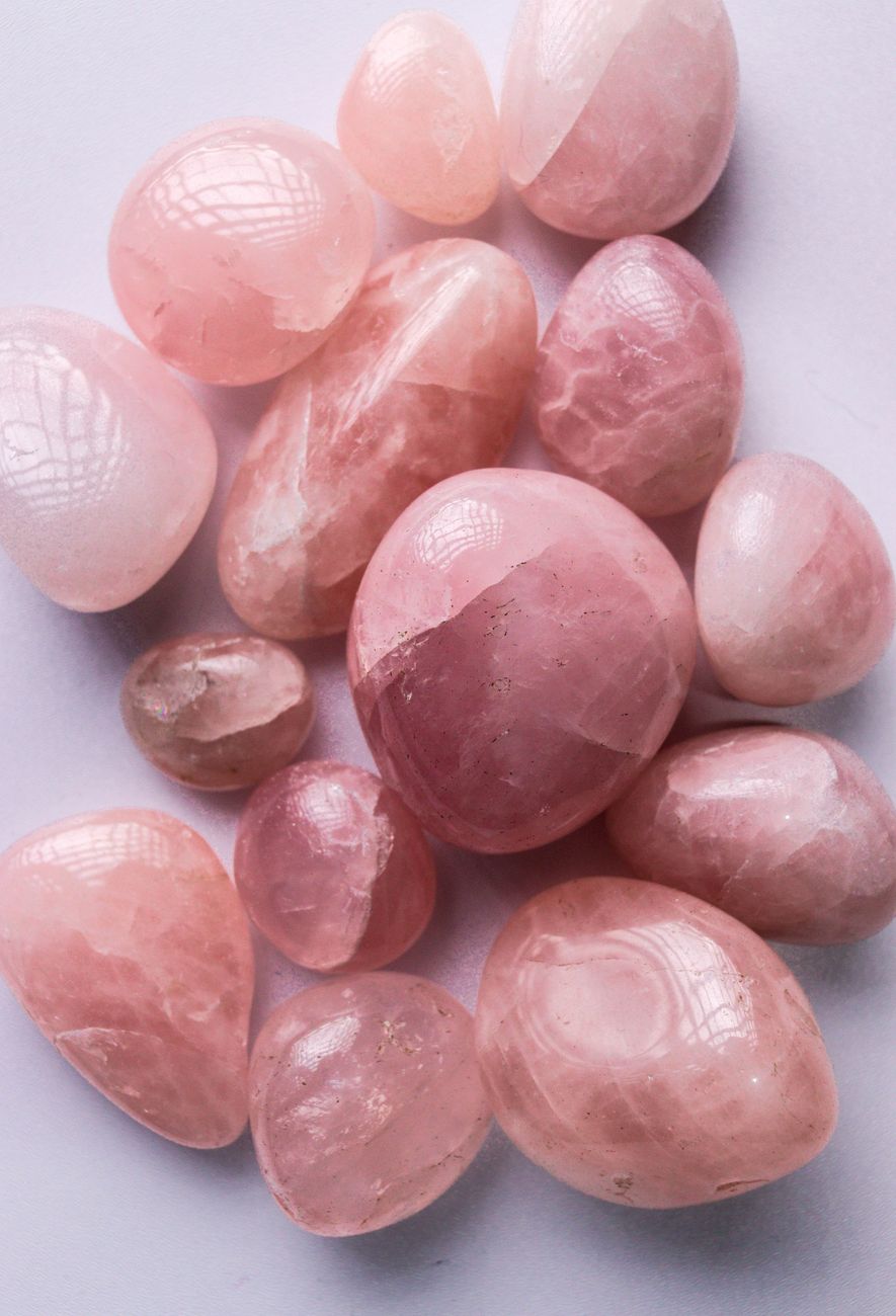close up of rose quartz gemstones on white surface