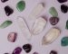 assorted various crystals and polished semiprecious stones against gray background
