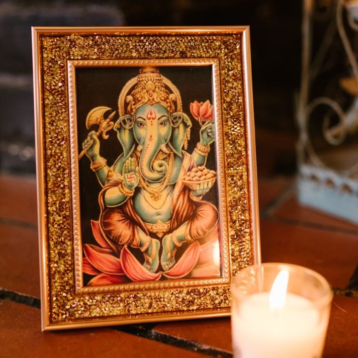 a gold framed image of ganesha