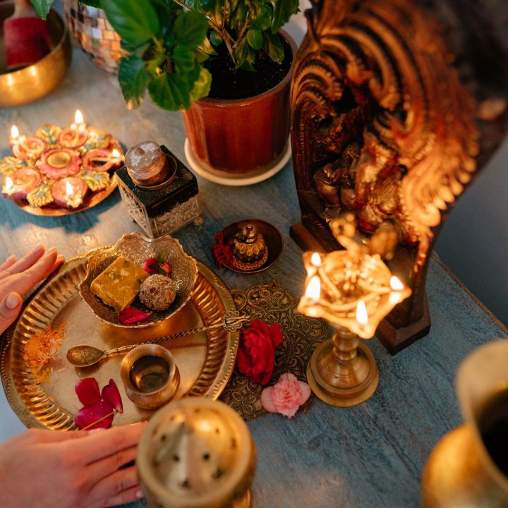 a person putting golden plate with food on the altar