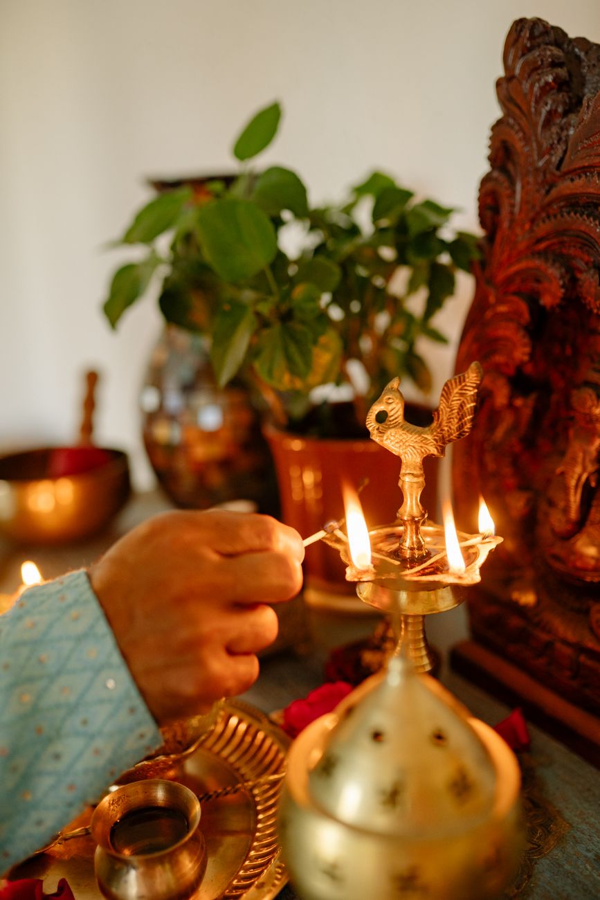 a hand lighting the candle on the holder