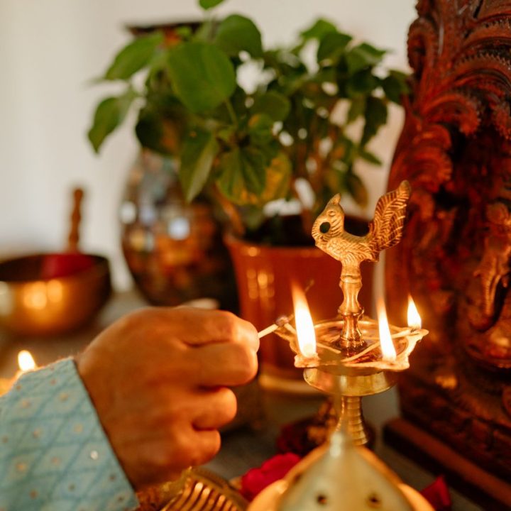 a hand lighting the candle on the holder